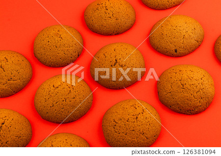 Freshly baked round cookies on vibrant red background Freshly baked round cookies on vibrant red background 126381094