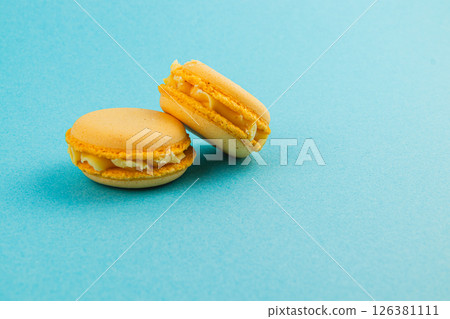 Delicious yellow macarons on a vibrant blue background 126381111