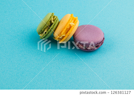 Colorful macarons arranged on blue background 126381127