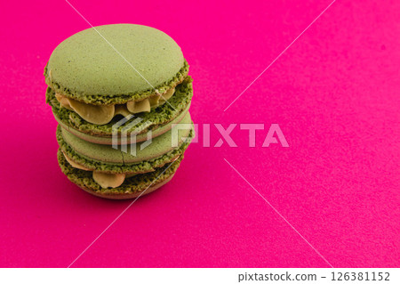Green macarons stacked on a vibrant pink background Green macarons stacked on a vibrant pink background 126381152