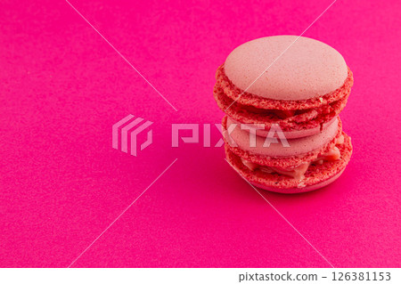 Delicious pink macarons stacked on a vibrant background 126381153