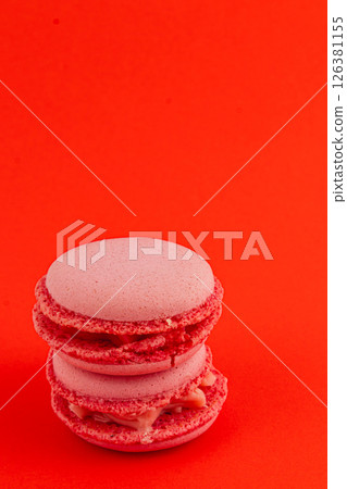 Delicious pink macarons stacked on a bright red background Delicious pink macarons stacked on a bright red background 126381155