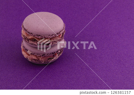 Purple macarons stacked on a vibrant purple background Purple macarons stacked on a vibrant purple background 126381157