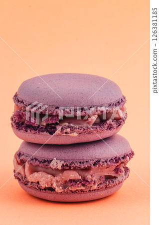Beautiful purple macarons stacked on an orange background Beautiful purple macarons stacked on an orange background 126381185