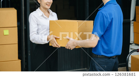 Express Delivery Service. Asian Courier Delivering Package to man Delivery service near van outside the warehouse, delivery home Express Delivery Service. Asian Courier Delivering Package to man Delivery service near van outside the warehouse, delivery home 126381681