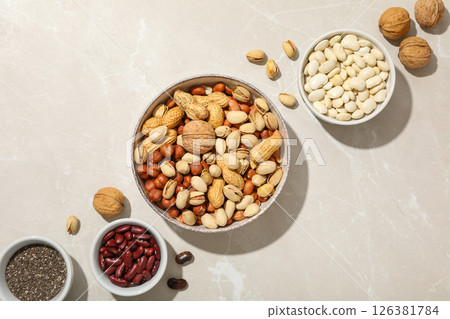 Beans, nuts and chia seeds in bowls on light background, top view 126381784