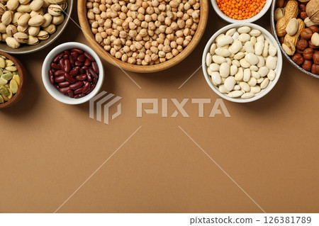 Beans, nuts and seeds in bowls on beige background, space for text Beans, nuts and seeds in bowls on beige background, space for text 126381789