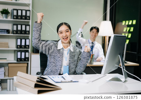 Young attractive Asian female office worker business suits smiling at camera with working 126381875