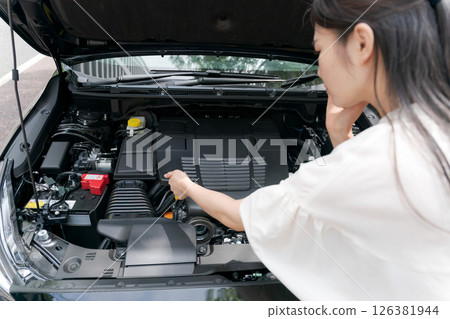 Woman repairing a car Woman repairing a car 126381944