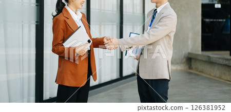 Business people shaking hands during a meeting. Two happy young businessmen and businesswoman 126381952