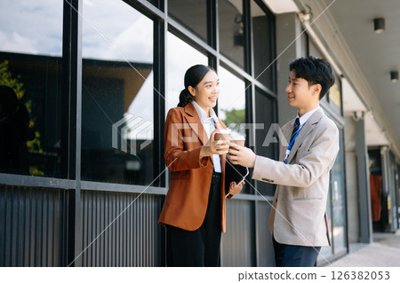 Happy two Asian business holding coffee cup in modern office 126382053