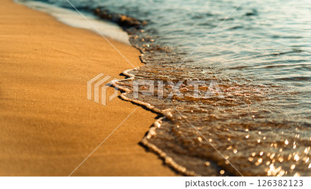 Sand on the beach and sea waves in the morning, orange tone. 126382123
