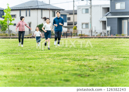 一家人在公園的草地上奔跑 126382243