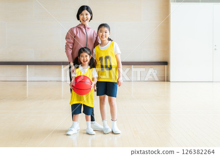 Children playing basketball and a female coach 126382264