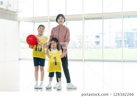 Children playing basketball and a female coach Children playing basketball and a female coach 126382266