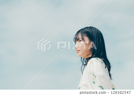 一位身穿白衣的女子站在安靜的海灘上 一位身穿白衣的女子站在安靜的海灘上 126382547