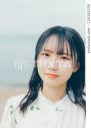 A woman in white standing on a quiet beach A woman in white standing on a quiet beach 126382558