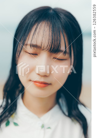 A woman in white standing on a quiet beach A woman in white standing on a quiet beach 126382559