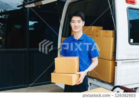 Asian courier delivery man searching the address on digital tablet. near van outside the warehouse. This is a freight transportation Asian courier delivery man searching the address on digital tablet. near van outside the warehouse. This is a freight transportation 126382603