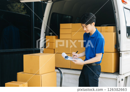 Asian courier delivery man searching the address on digital tablet.  near van outside the warehouse. This is a freight transportation 126382663