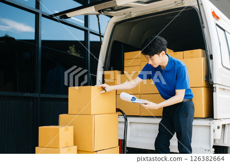 Asian courier delivery man searching the address on digital tablet.  near van outside the warehouse. This is a freight transportation 126382664