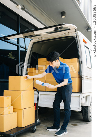 Asian courier delivery man searching the address on digital tablet.  near van outside the warehouse. This is a freight transportation 126382665
