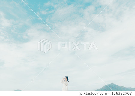 Girl holding a film camera on the beach 126382708
