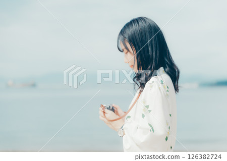 沙灘上拿著底片相機的女孩 沙灘上拿著底片相機的女孩 126382724
