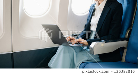 Asian executive excels in first class, multitasking with digital tablet, laptop. Travel in style, work with grace. Asian executive excels in first class, multitasking with digital tablet, laptop. Travel in style, work with grace. 126382816