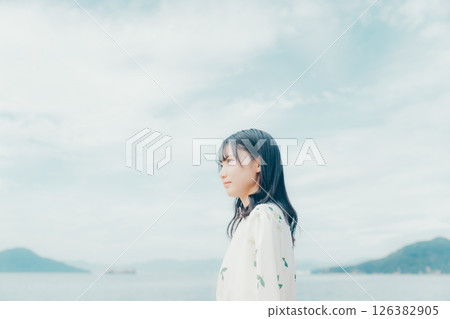 A young woman in natural clothing standing on the beach A young woman in natural clothing standing on the beach 126382905