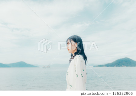 一位身著自然服裝的年輕女子站在海灘上 一位身著自然服裝的年輕女子站在海灘上 126382906