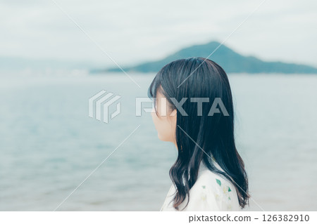 A young woman in natural clothing standing on the beach 126382910