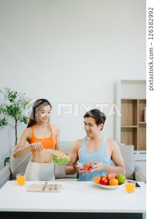 Fitness duo celebrating healthy living with fresh salad, fruits, and juice. A perfect balance of wellness, nutrition Fitness duo celebrating healthy living with fresh salad, fruits, and juice. A perfect balance of wellness, nutrition 126382992
