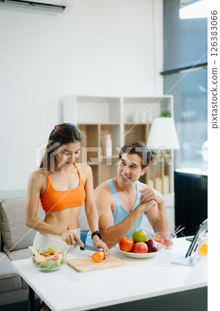 Fitness duo celebrating healthy living with fresh salad, fruits, and juice. A perfect balance of wellness, nutrition 126383066