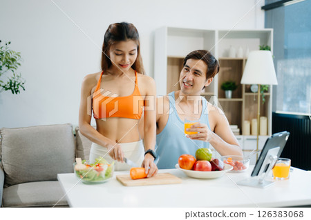 Fitness duo celebrating healthy living with fresh salad, fruits, and juice. A perfect balance of wellness, nutrition Fitness duo celebrating healthy living with fresh salad, fruits, and juice. A perfect balance of wellness, nutrition 126383068