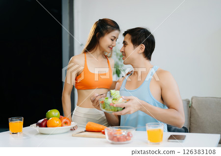 Fitness duo celebrating healthy living with fresh salad, fruits, and juice. A perfect balance of wellness, nutrition Fitness duo celebrating healthy living with fresh salad, fruits, and juice. A perfect balance of wellness, nutrition 126383108
