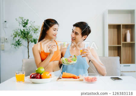 Fitness duo celebrating healthy living with fresh salad, fruits, and juice. A perfect balance of wellness, nutrition Fitness duo celebrating healthy living with fresh salad, fruits, and juice. A perfect balance of wellness, nutrition 126383118