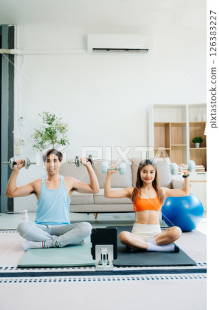 Fitness duo high fiving during an energetic workout session at home, featuring yoga mats, gym equipment Fitness duo high fiving during an energetic workout session at home, featuring yoga mats, gym equipment 126383227