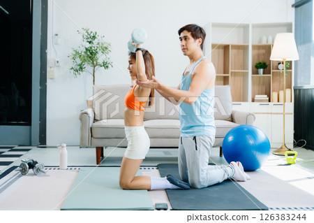 Fitness duo high fiving during an energetic workout session at home, featuring yoga mats, gym equipment Fitness duo high fiving during an energetic workout session at home, featuring yoga mats, gym equipment 126383244