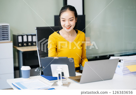Asian Businesswoman Analyzing Finance on Tablet and Laptop at modern Office Desk tax Asian Businesswoman Analyzing Finance on Tablet and Laptop at modern Office Desk tax 126383656