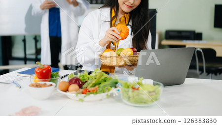 Professional nutritionist reviewing fresh vegetables and supplements for diet planning, health care, 126383830