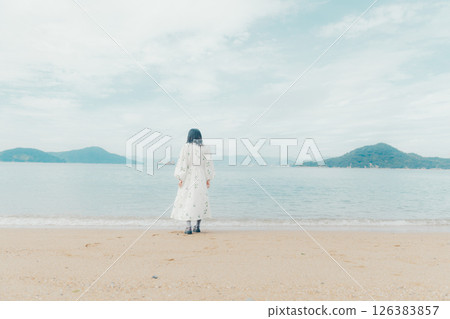 A calm sea and the back of a woman holding a lantern A calm sea and the back of a woman holding a lantern 126383857