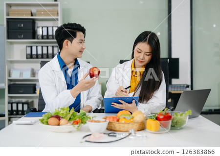 Nutritionists consulting on healthy food choices, meal planning, and wellness concepts Nutritionists consulting on healthy food choices, meal planning, and wellness concepts 126383866