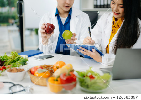 Nutritionists consulting on healthy food choices, meal planning, and wellness concepts Nutritionists consulting on healthy food choices, meal planning, and wellness concepts 126383867