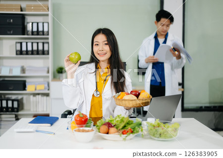 Nutritionists consulting on healthy food choices, meal planning, and wellness concepts Nutritionists consulting on healthy food choices, meal planning, and wellness concepts 126383905