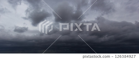 The dark sky filled with swirling clouds forebodes an approaching windstorm, showcasing the power of nature's forces and the dramatic shifts in weather during turbulent atmospheric conditions. 126384927
