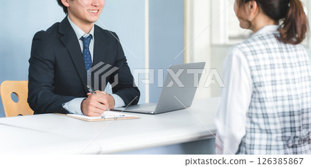 A businessman and a businesswoman serving customers at the reception desk A businessman and a businesswoman serving customers at the reception desk 126385867