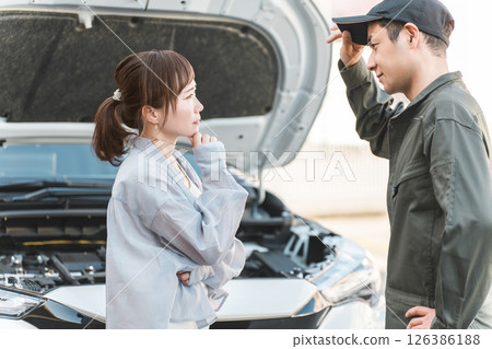 A male worker and a female driver rushed to the road for road service. 126386188