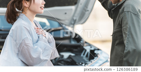 一名男工人和一名女司機趕到路上進行道路服務。 一名男工人和一名女司機趕到路上進行道路服務。 126386189