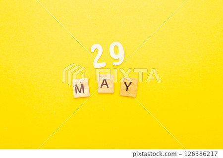 Top view of word 29 May calendar date made by wooden cubes on yellow color background 126386217